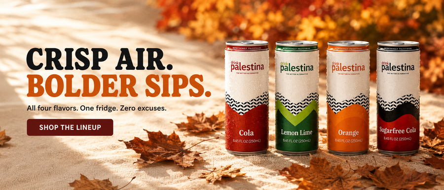 Four Palestina canned sodas stand on a sandy surface outdoors with autumn leaves and warm sunlight. The cans are labeled Cola, Lemon Lime, Orange, and Sugarfree Cola.